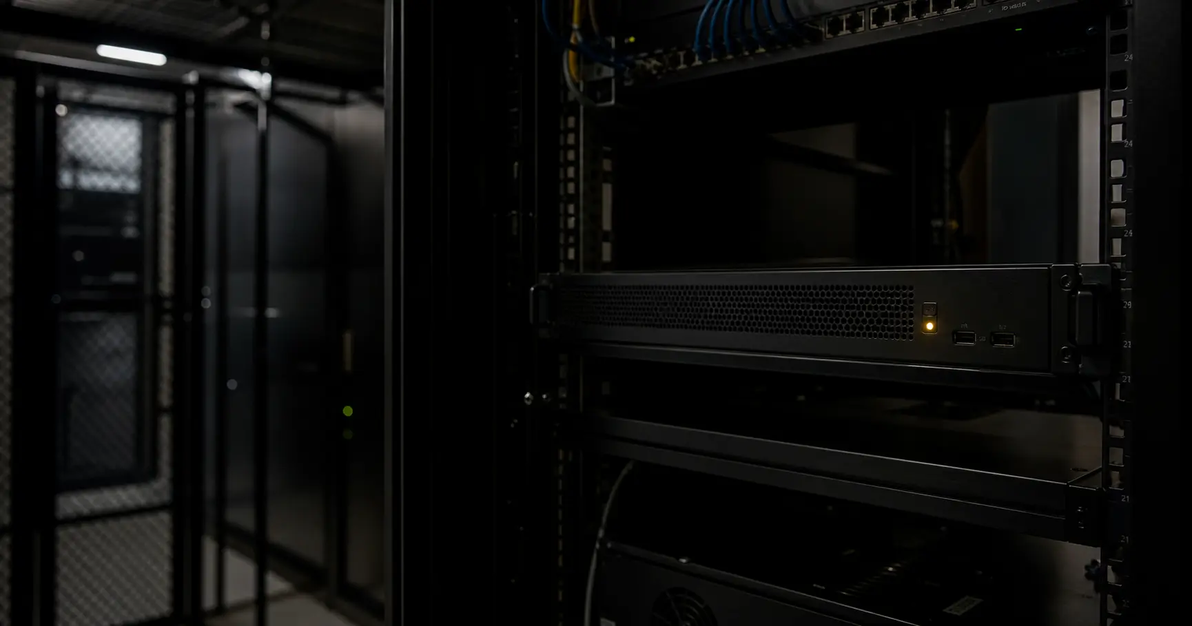 A dimly lit server room with a single rack-mounted appliance, its amber status light glowing, representing a network presence that is registered but dormant, waiting for activation.