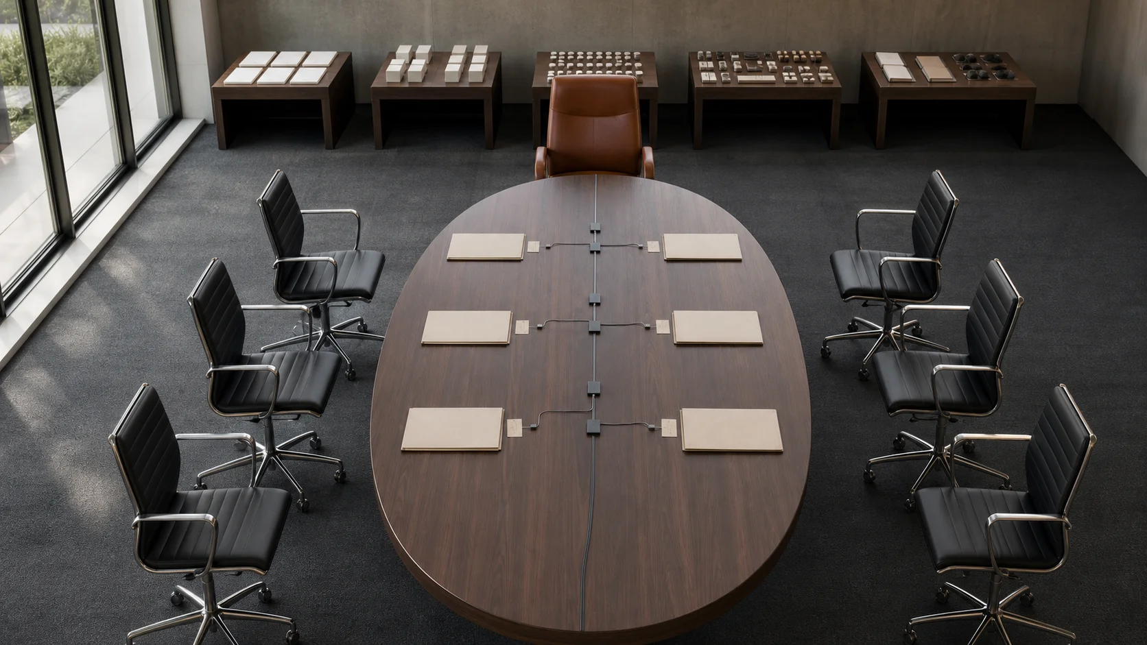 Six matching board chairs and one distinct executive chair face blank delegation folders connected to five chairless specialist worktables.