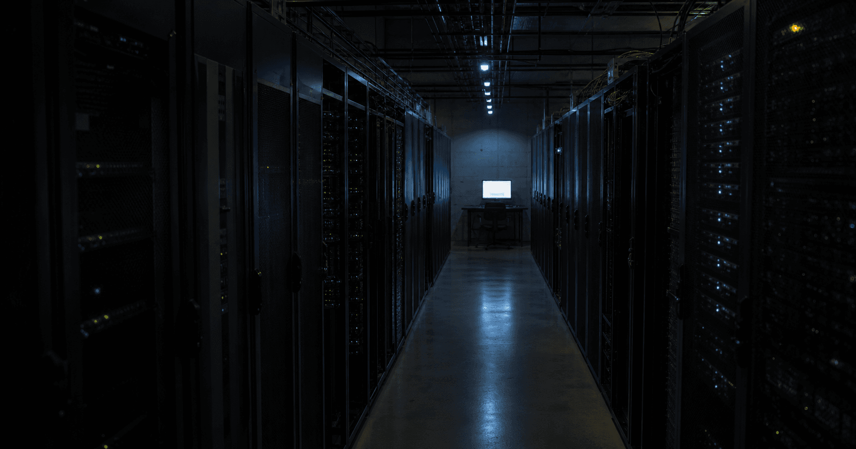 A dark server room with a single lit monitor displaying a RIPE database entry for AS210907.