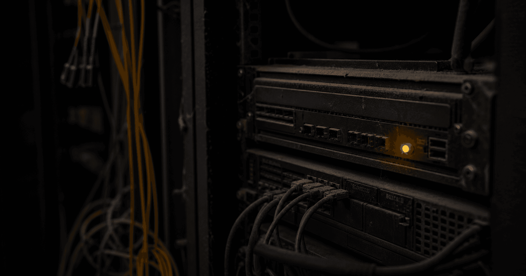 Dark server rack with a single amber LED and hanging cables, representing a dormant network registration.