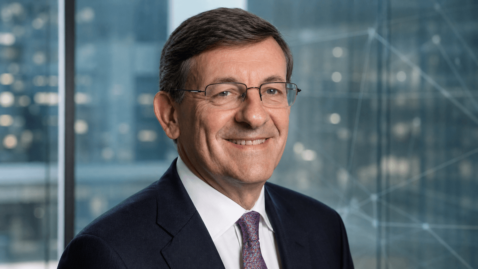 Editorial portrait of Vittorio Colao against a restrained digital infrastructure backdrop.