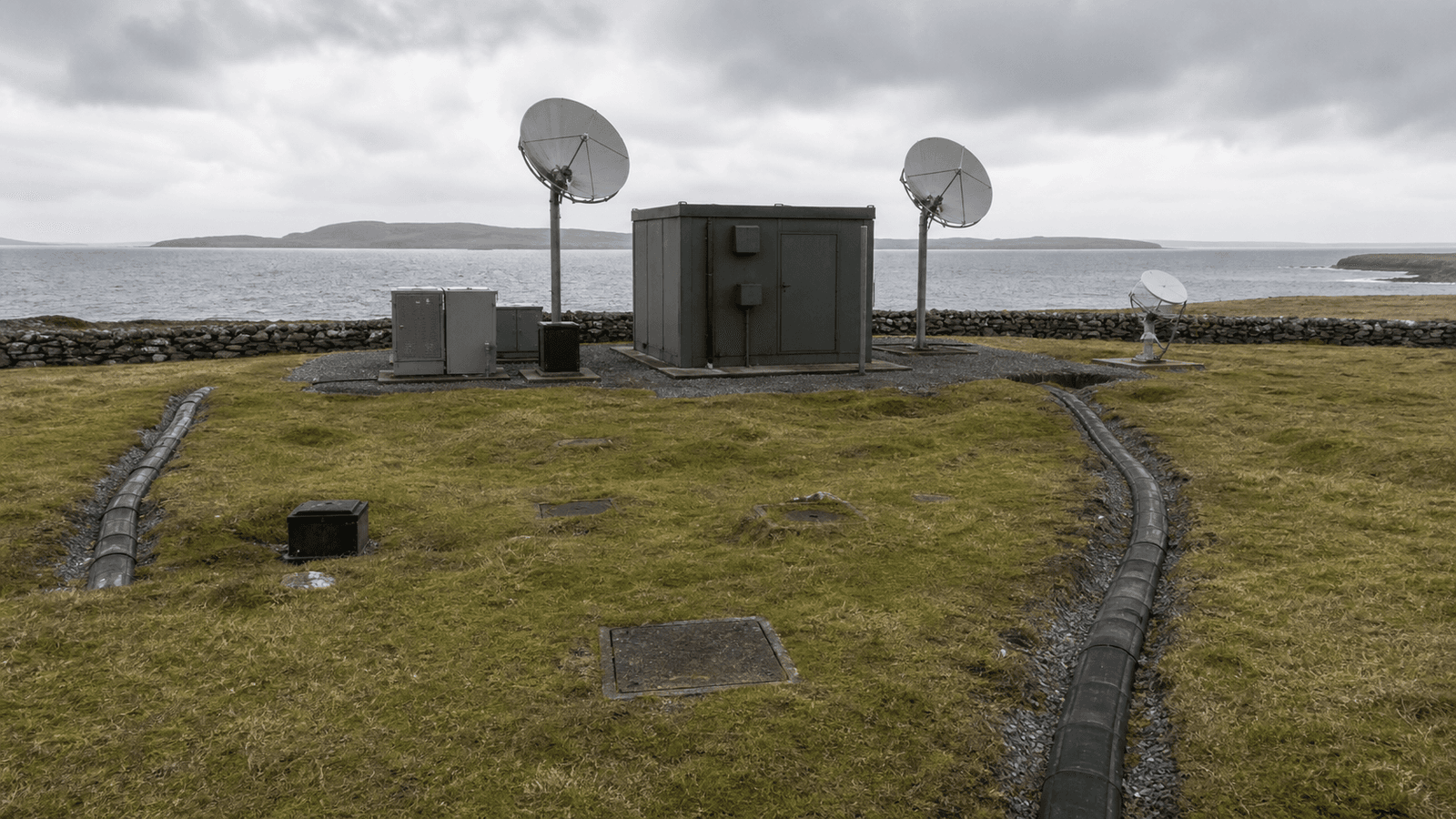 Generated coastal telecom landing site with separate conduit routes and microwave and satellite dishes.