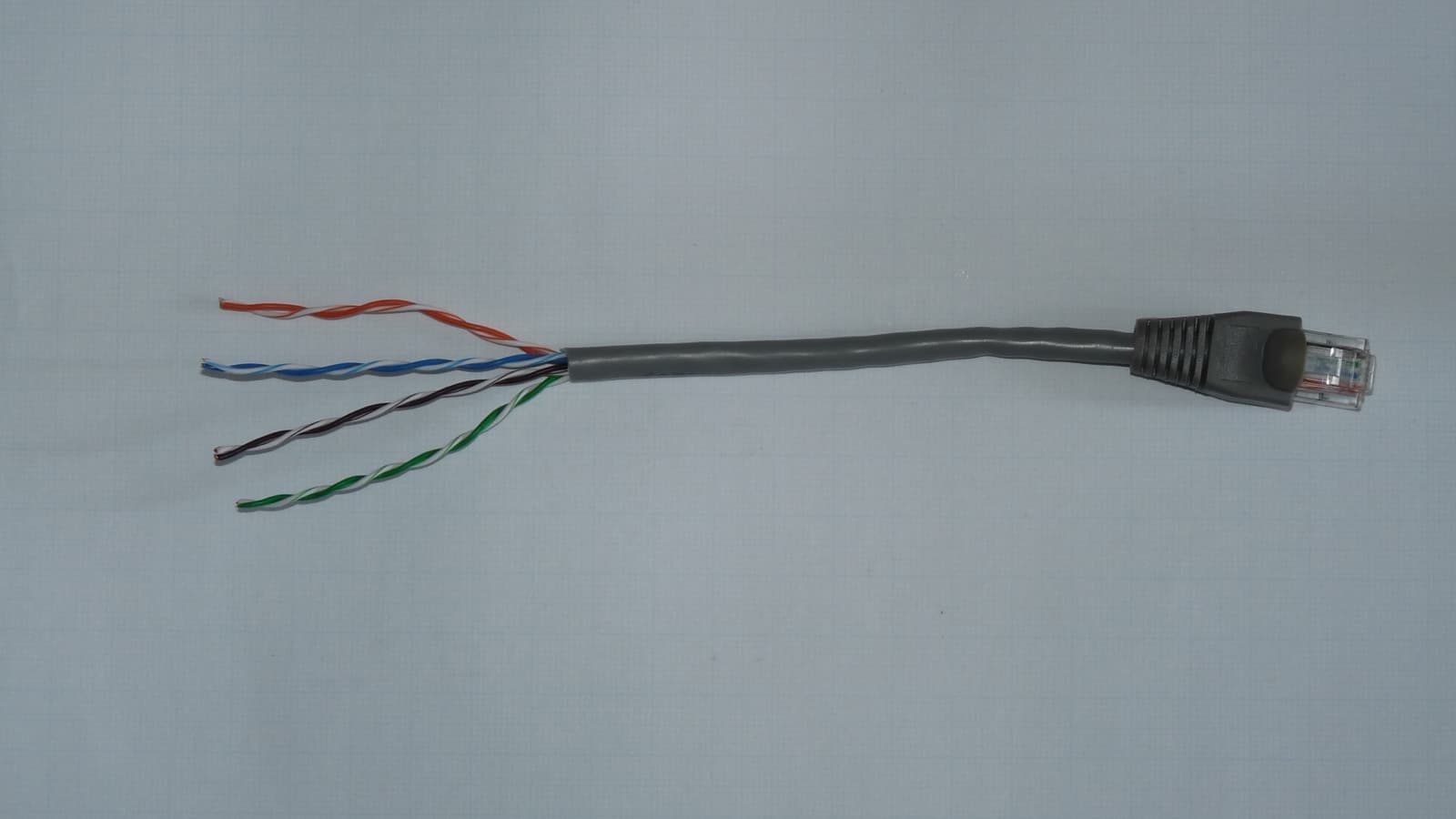 A grey Ethernet cable with its coloured twisted-pair conductors exposed on a neutral background.