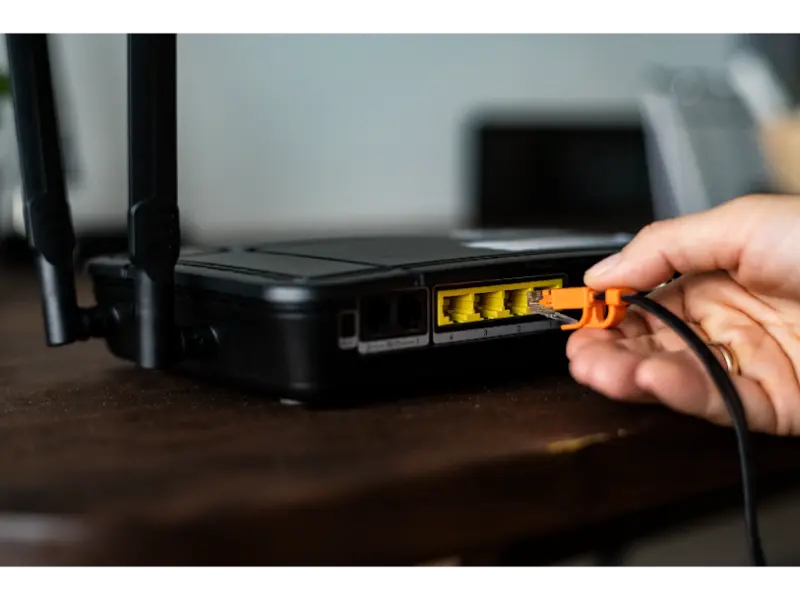 man-plugging-ethernet-cable-wireless-router-1